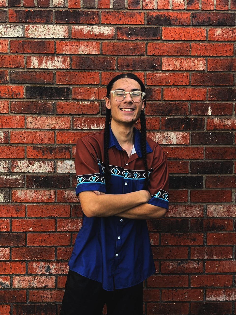 Sol Zendejas-Smith, owner of Curbsight Exteriors, standing in front of a brick wall in Yukon
